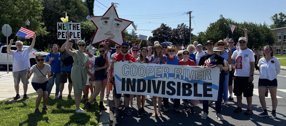 A diverse group of people standing behind the CRI Banner