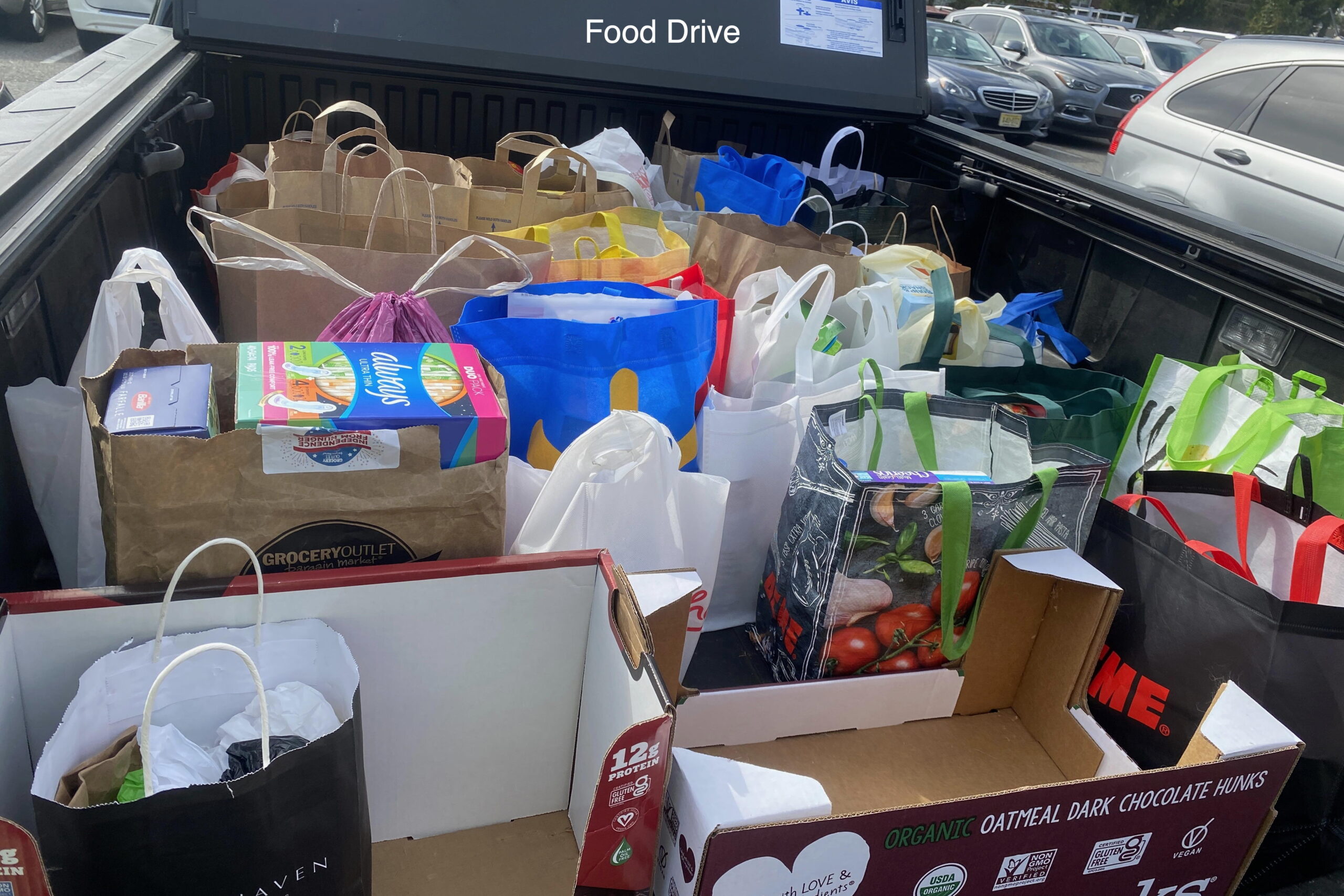 A pickup bed filled with bags of food for our food drive