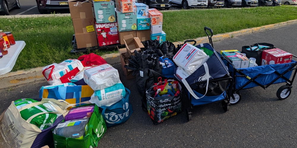 We are right along a curb and there is a pile of donated items. Diapers, Bags, and laundry detergent