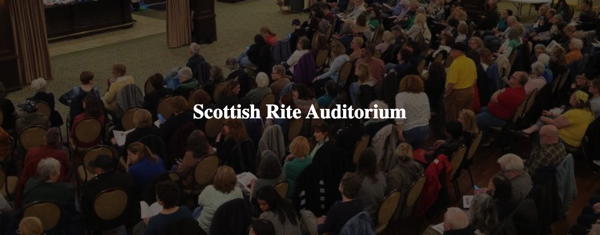 Shows an auditorium full of people with the words "Scottish Rite Auditorium" in the center