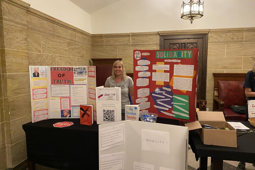 A series of presentations are laid out on the table in front of the leader of the book club.