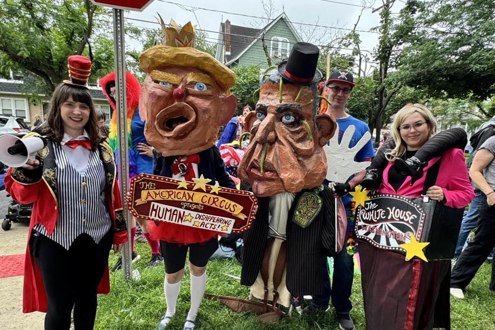 The members of the creative team pose for a picture. They are all in custom. The women on the right is dressed like a circus ring master. Some of the others have the caricatures on