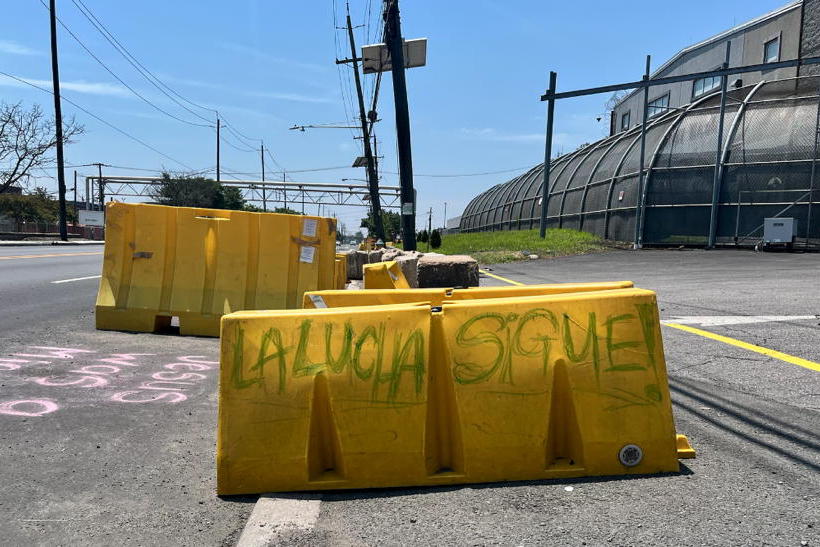 A yellow traffic barrier sits by a driveway near Delaney Hall on a hot desolate afternoon