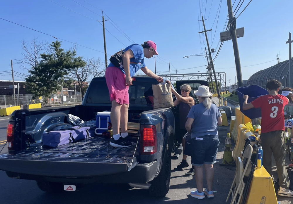 People unload a pickup truck filled with things being donated to the families of detainees at Delaney Hall