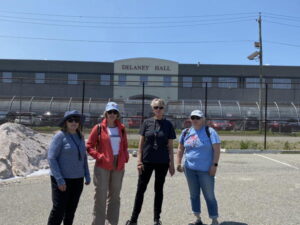 Four members of the CRI immigration team stand in front of Delaney Hall on a beautiful Spring Day