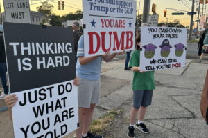 Protestors stand along Black Horse Pike holding signs