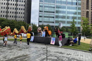 A stage in Philadelphia's Love Park. A group from Philadelphia is carrying a dragon