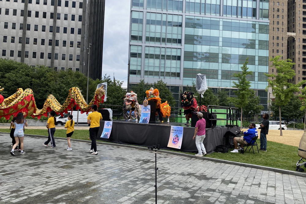 A stage in Philadelphia's Love Park. A group from Philadelphia is carrying a dragon