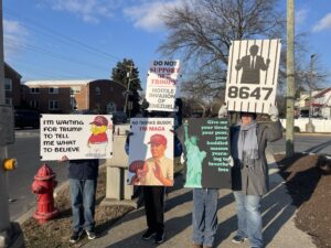 A group of people stand on the corner of haddon and cuthbert roads protesting against the illegal actions in venezuela