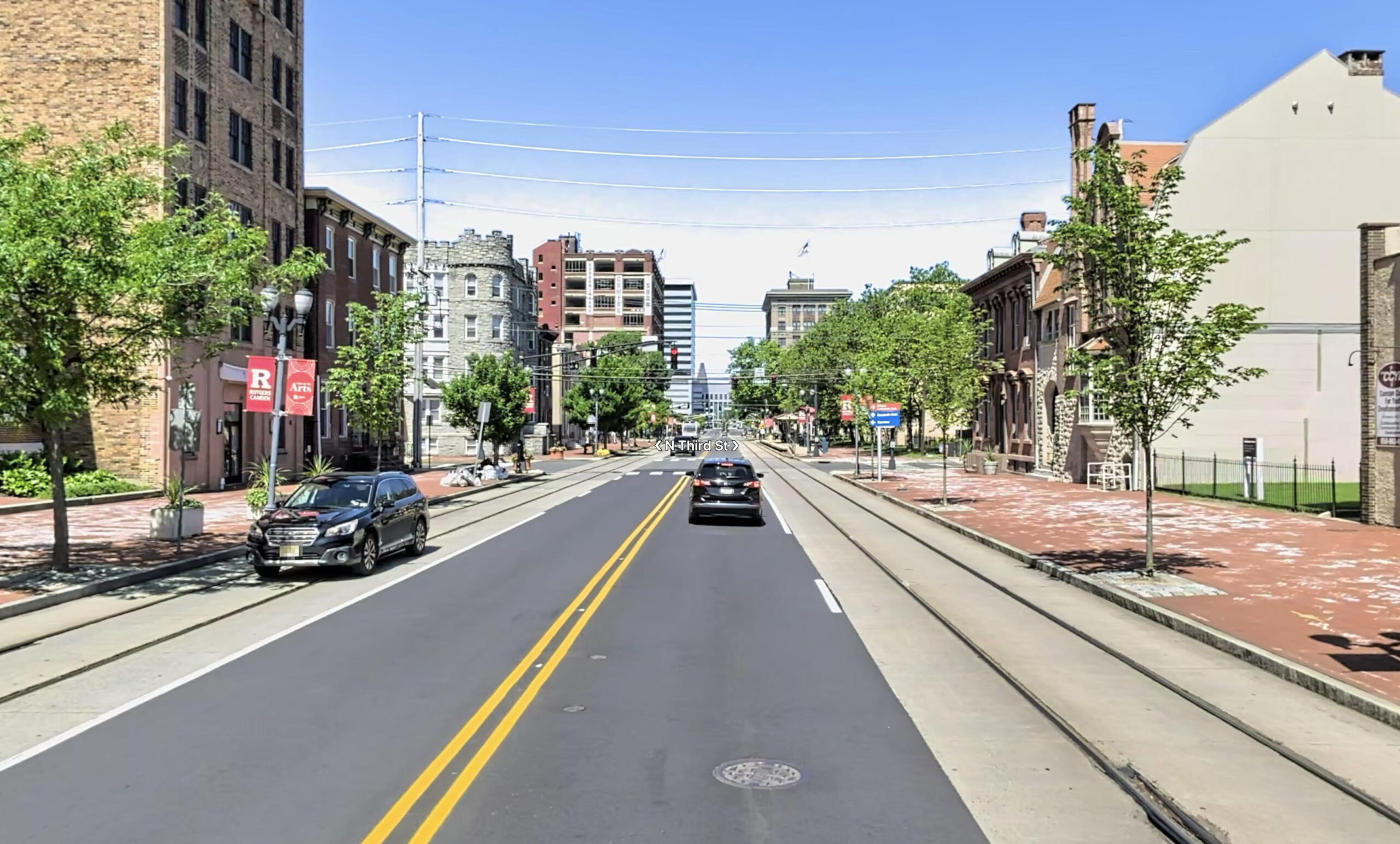 A screen shot of a street mapping program. A view down Cooper Street with railroad tracks on each side and trees lining the sidewalks