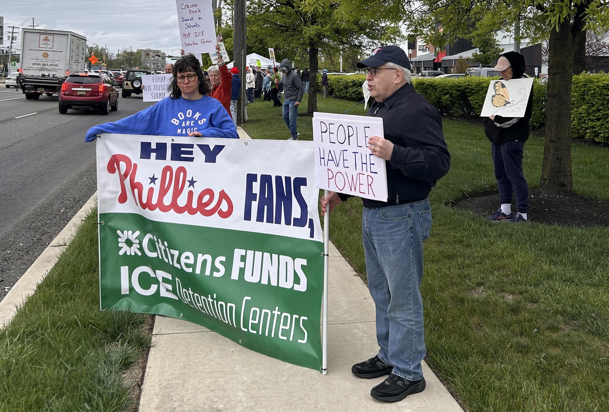 People stand by the road protesting against Citizens Bank and their funding of ICE Detention Centers