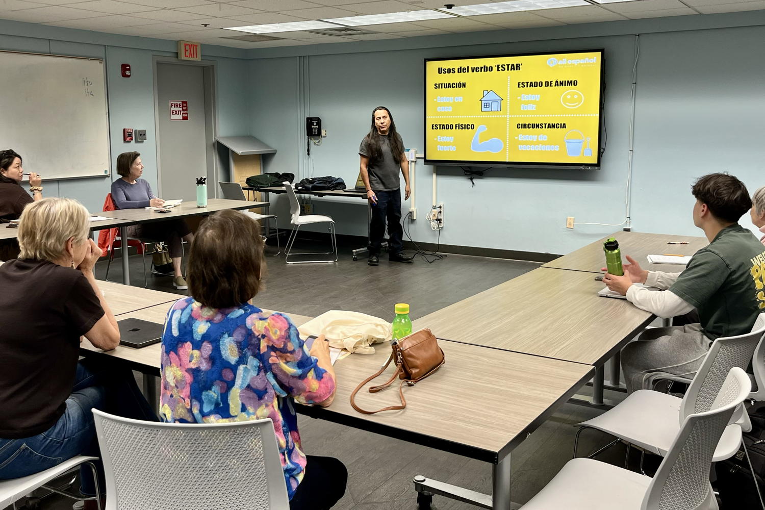 We are in the meeting room in Camden County Library. The desks form a U and the students are arranged to see the tv with the spanish lesson